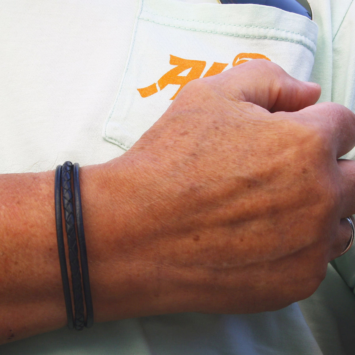 lederarmband-herren-schwarz-trio-geflochten-Edelstahlverschluss-getragen-wavepirate-shop-f
